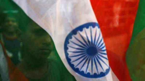 A boy&#039;s face is seen through the Indian natio<em></em>nal flag during Independence day celebrations in Mumbai, India, August 15, 2018/ Reuters 