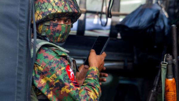 A soldier uses a mobile phone as he sit inside a military vehicle outside Myanmar&#039;s Central Bank during a protest against the military coup, in Yangon, Myanmar, February 15, 2021. REUTERS/Stringer/File Photo