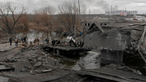 People cross a destroyed bridge as they try to leave the city of Irpin, in the Kyiv region, Ukraine March 5, 2022. Jedrzej Nowicki/Agencja Wyborcza.pl via REUTERS