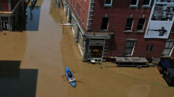  People paddle a kayak down a street flooded by recent rain storms in Montpelier, Vermont, U.S., July 11, 2023. REUTERS/Brian Snyder