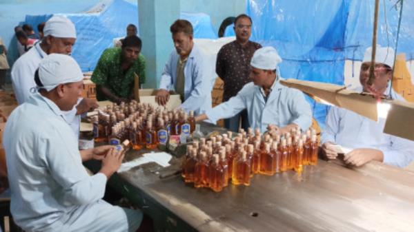 Employees of Carew and Company Limited, the country’s o<em></em>nly licenced distillery that produces alcohol by fermenting sugar molasses, label liquor bottles at its distillery unit at Darshana in Chuadanga. The photo was taken recently. Photo: TBS