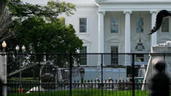 Workers are seen behind layers of security fencing in front of the White House the day before the presidential election in Washington, DC, 2 November, 2020. Photo: ABC News