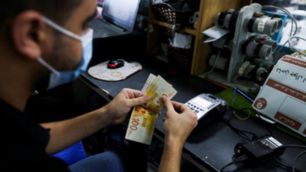 Palestinians receive cash as the United Nations begins distribute cash aid, funded by Qatar, to thousands of poor families, in Khan Younis, in the southern Gaza Strip, September 15, 2021. REUTERS/Ibraheem Abu Mustafa/File Photo