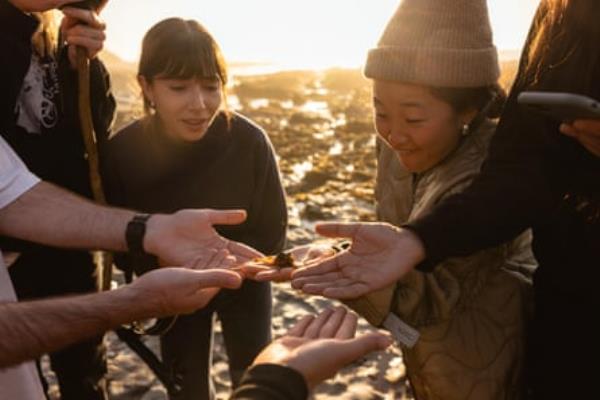 group of people inspect specimen outside