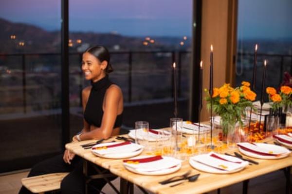 woman sits for a portrait at a set dinner table