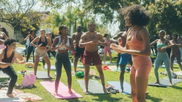 large group of people doing yoga outside