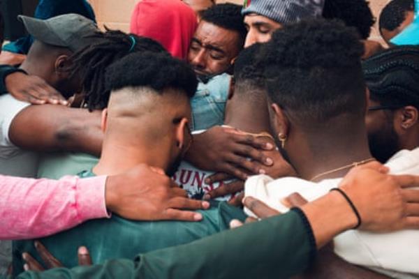 close up of group of men embracing